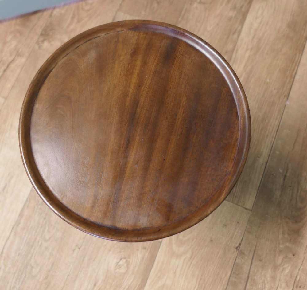 A small Victorian mahogany wine table featuring a circular dished top, a turned and carved central column, and three swept tripod legs. View VI