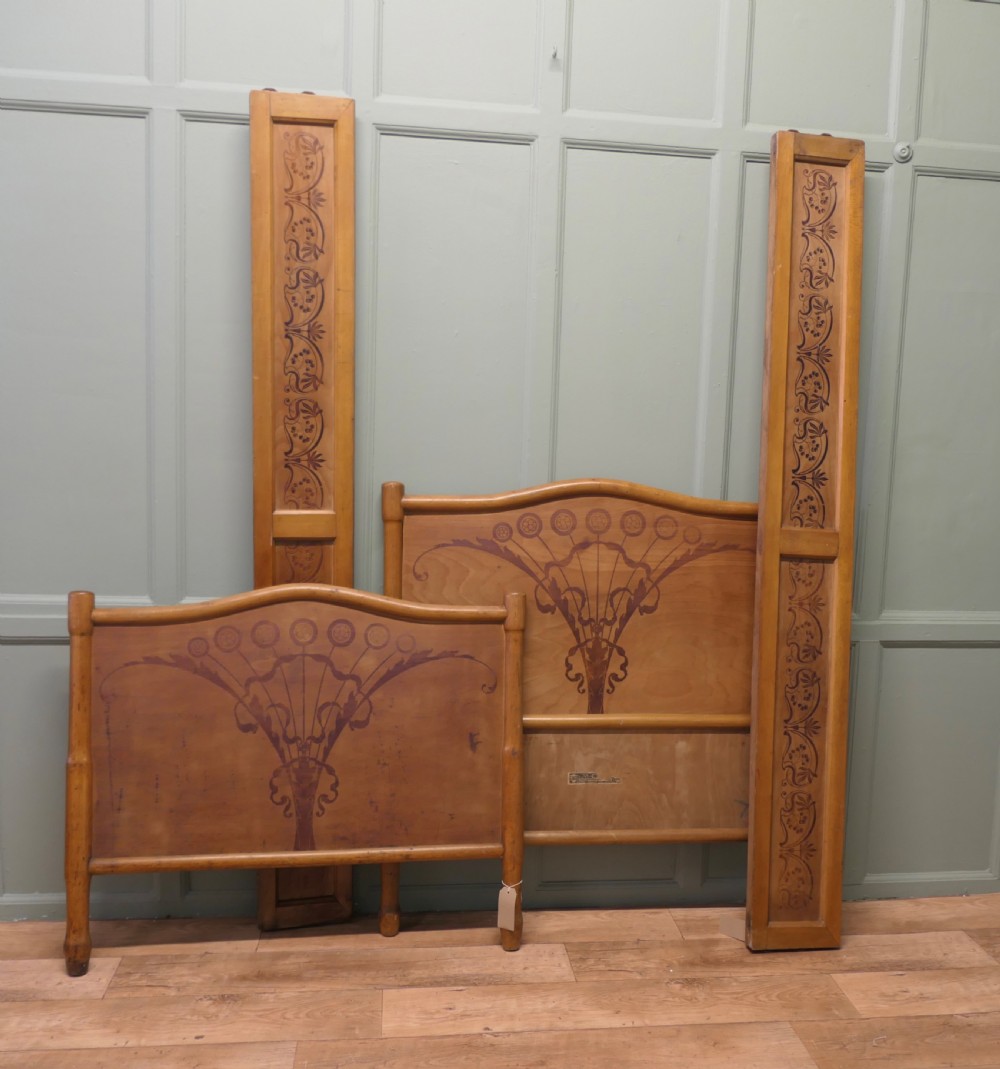 An antique Vienna Secession single wooden bedstead featuring arched headboard and footboard panels decorated with stylised botanical marquetry motifs. View VII