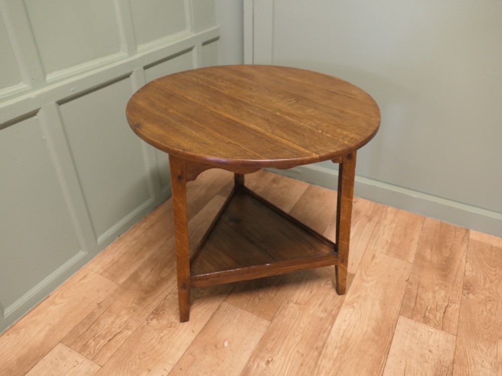 A Georgian oak cricket table featuring a circular top, three straight square legs, and a lower triangular under-shelf. View III