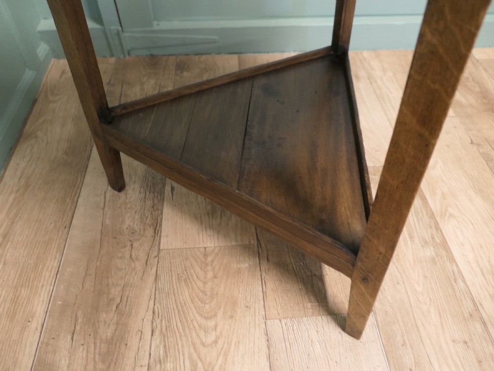 A Georgian oak cricket table featuring a circular top, three straight square legs, and a lower triangular under-shelf. View IV