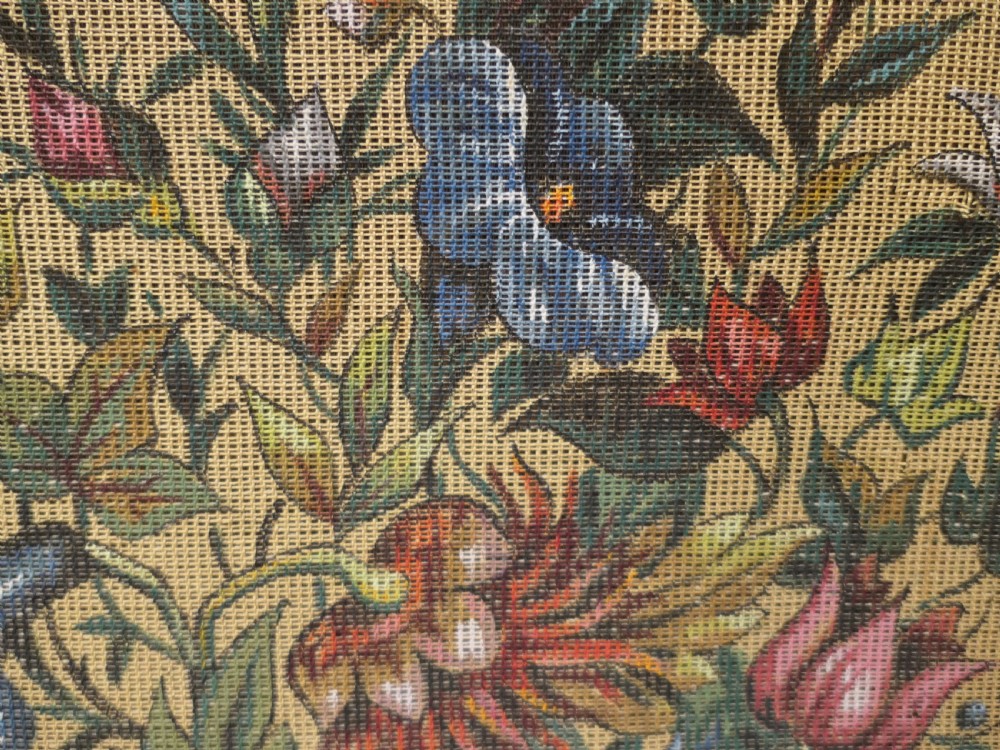A Victorian mahogany fire screen featuring spiral barley twist supports, an openwork carved scroll cresting, and a central needlework panel depicting a colourful floral bouquet. View V