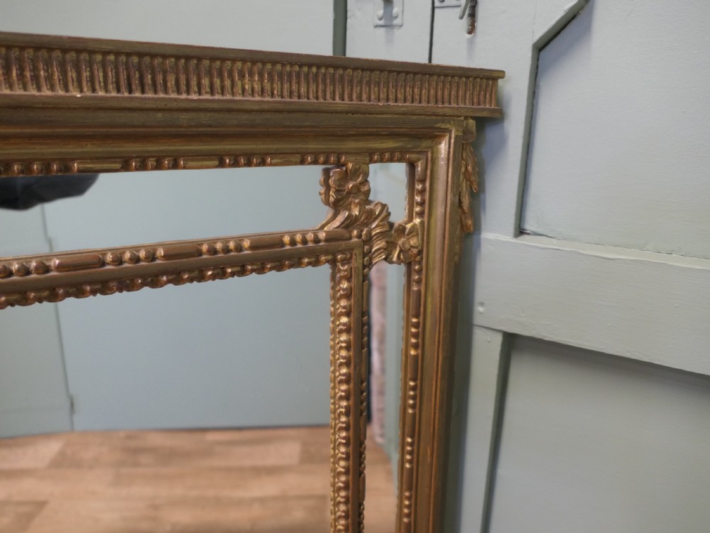 A large rectangular French giltwood cushion mirror featuring beaded trim moulding and marginal border mirror plates. View III