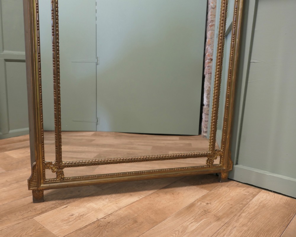 A large rectangular French giltwood cushion mirror featuring beaded trim moulding and marginal border mirror plates. View IV