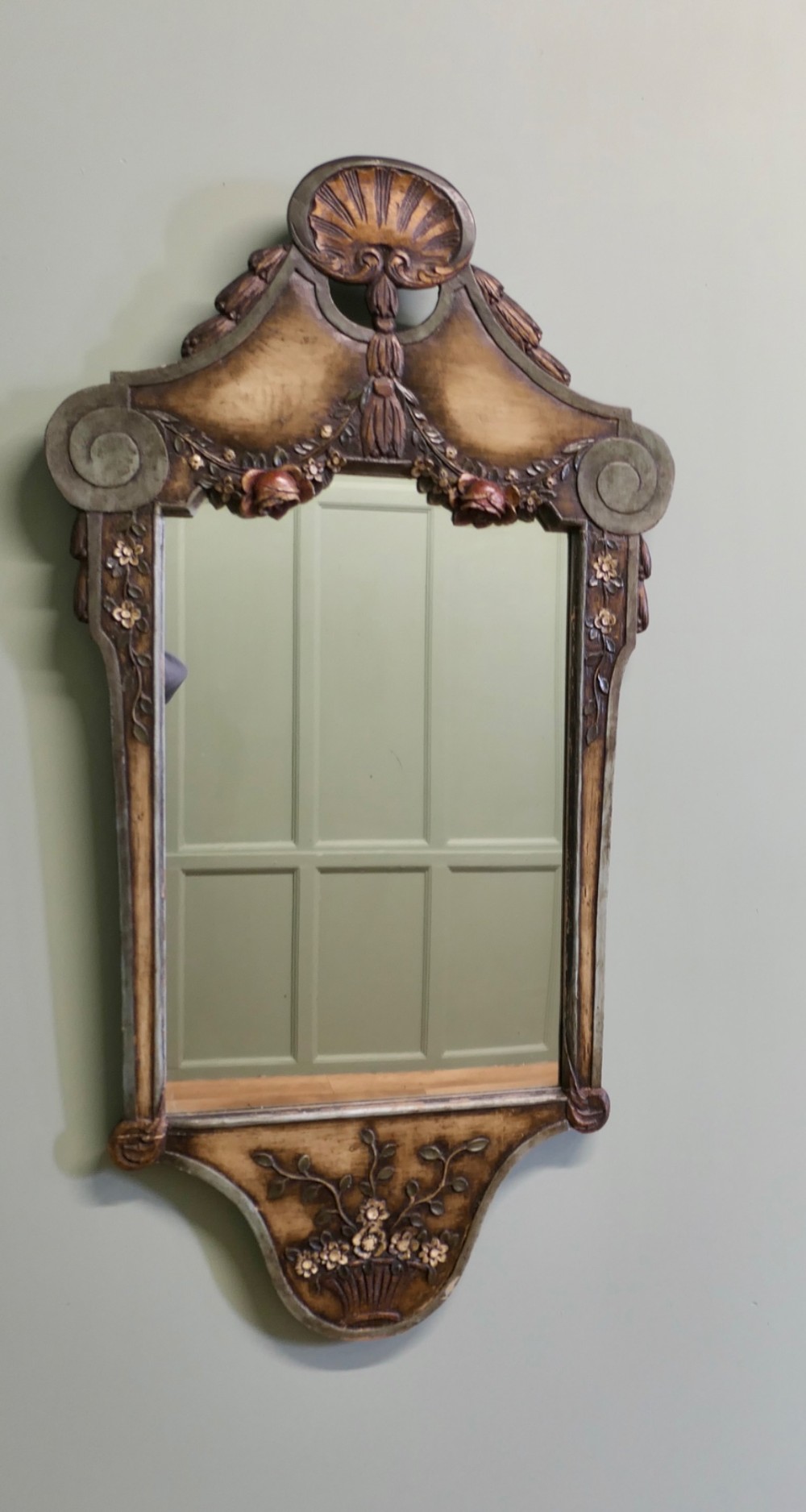A 19th-century Northern Italian Baroque style wall mirror featuring a carved wooden frame with a scallop shell crest and polychrome floral carvings. View V