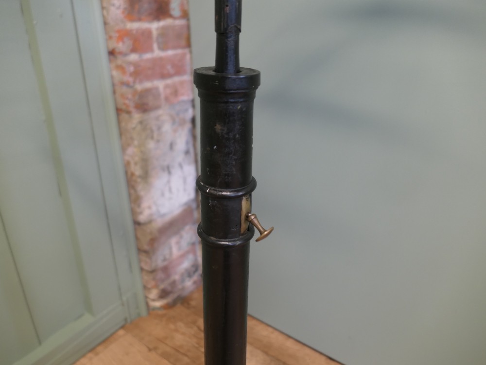 An ebonised wooden duet music stand featuring a double-sided slatted rest, height-adjustable central column, tripod base, and two brass candle sconces. View II