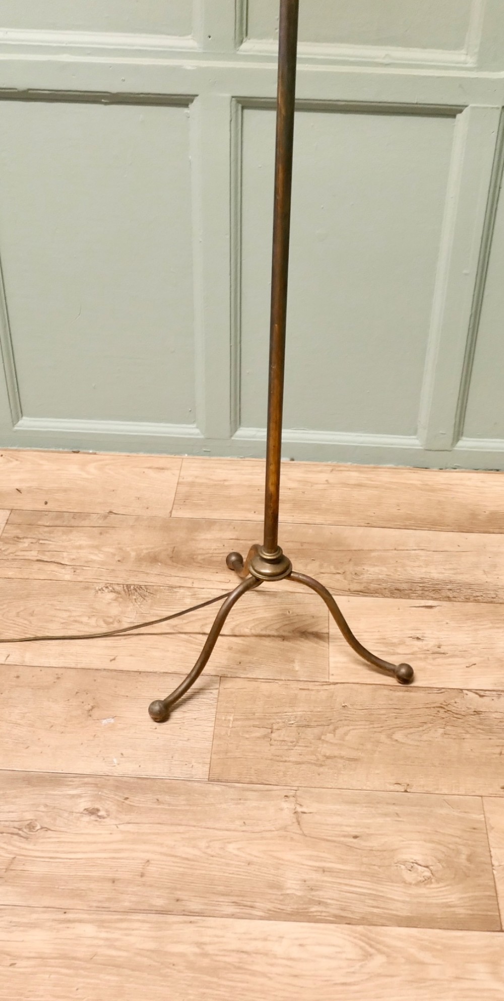 A French Arts and Crafts brass floor lamp featuring a slender stem, tripod base, curved adjustable arm, and a mottled parchment shade. View II