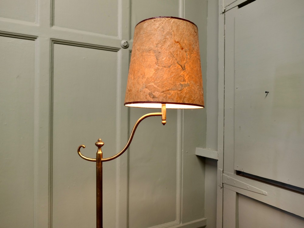 A French Arts and Crafts brass floor lamp featuring a slender stem, tripod base, curved adjustable arm, and a mottled parchment shade. View VI