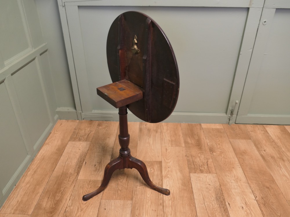 A circular solid oak tilt-top table with a turned central pedestal resting on three cabriole tripod feet. View VI