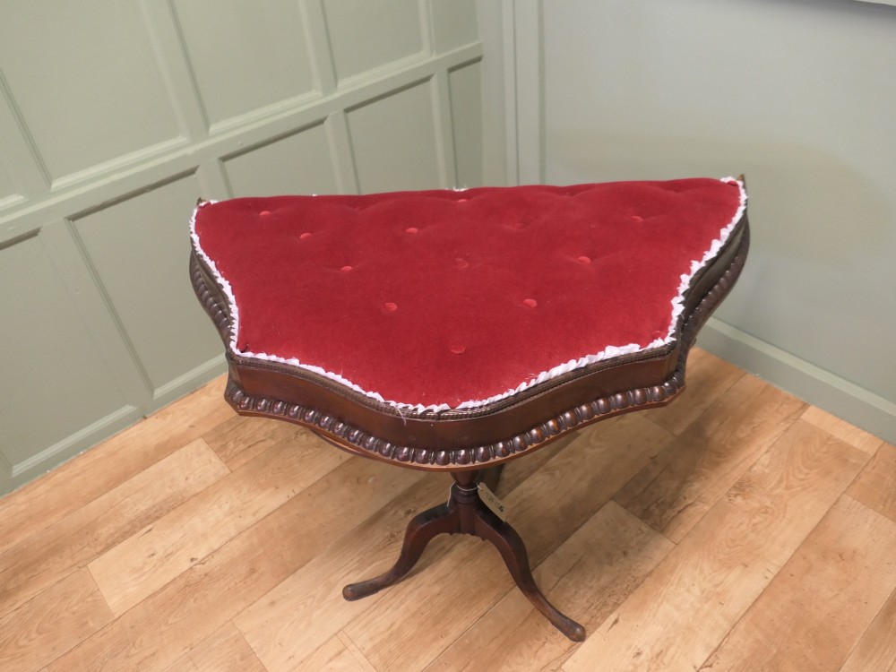 A 19th-century shaped wooden bed canopy corona featuring carved beaded moulding and a deep red button-tufted velvet underside with white ruffled trim. View III