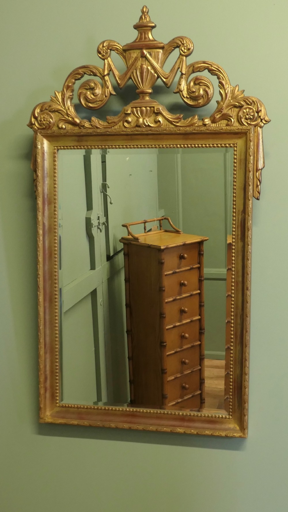 A rectangular French Napoleon III wall mirror featuring a gilded wood frame with a beaded inner edge and an elaborate carved top crest depicting an urn flanked by scrollwork. View IV