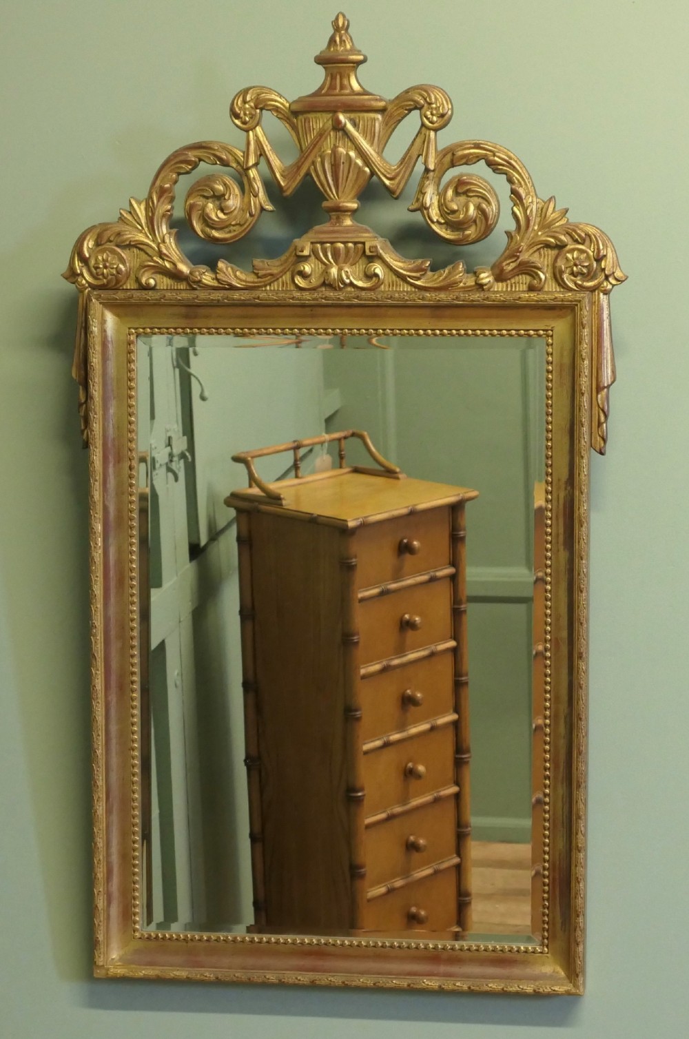 A rectangular French Napoleon III wall mirror featuring a gilded wood frame with a beaded inner edge and an elaborate carved top crest depicting an urn flanked by scrollwork. View V