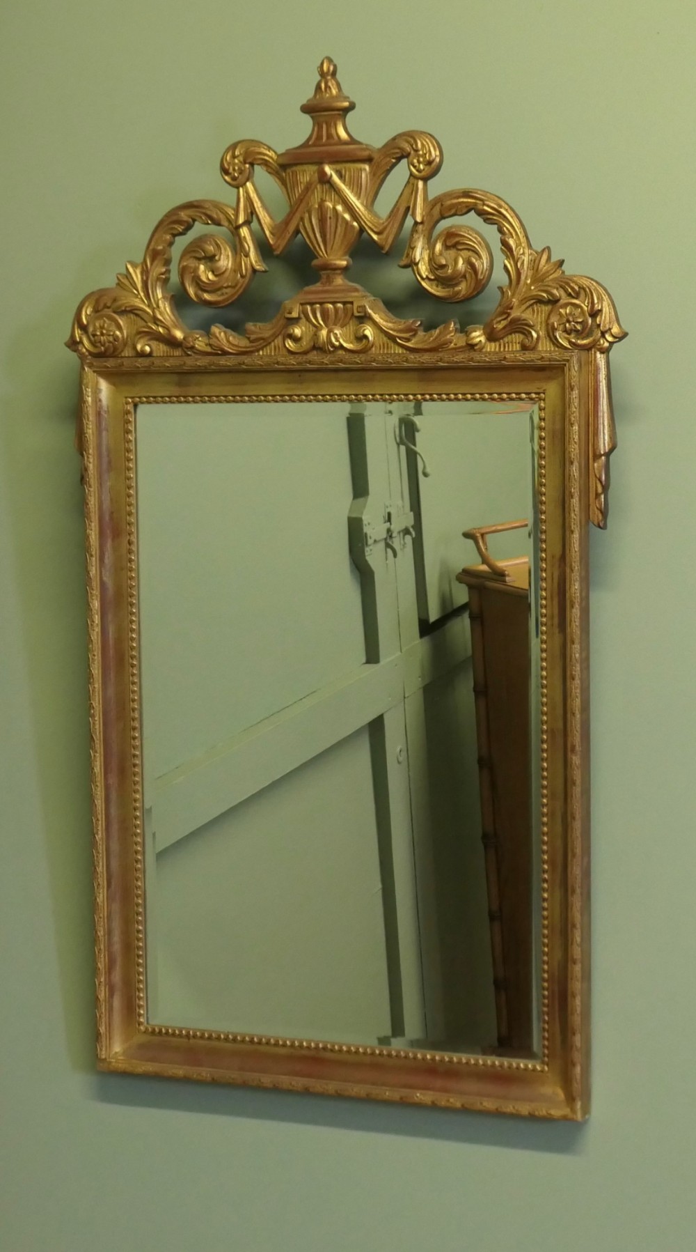 A rectangular French Napoleon III wall mirror featuring a gilded wood frame with a beaded inner edge and an elaborate carved top crest depicting an urn flanked by scrollwork. View VI
