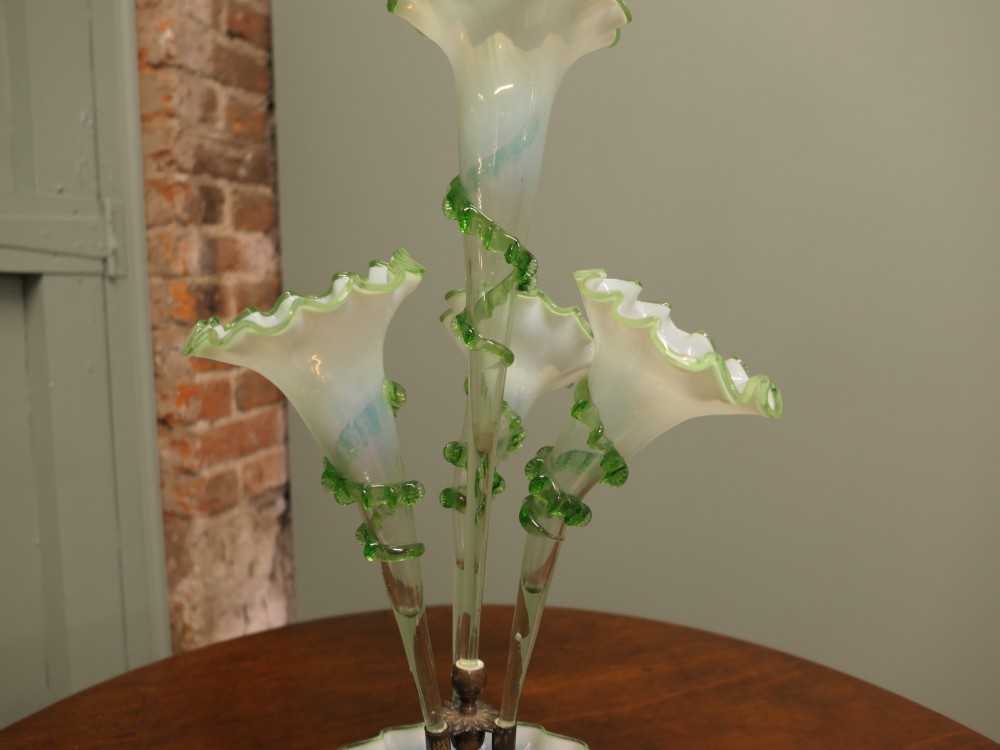 A nineteenth-century hand-blown uranium glass epergne featuring four crimped trumpet stems with applied green glass trailing mounted above an opalescent bowl base. View II