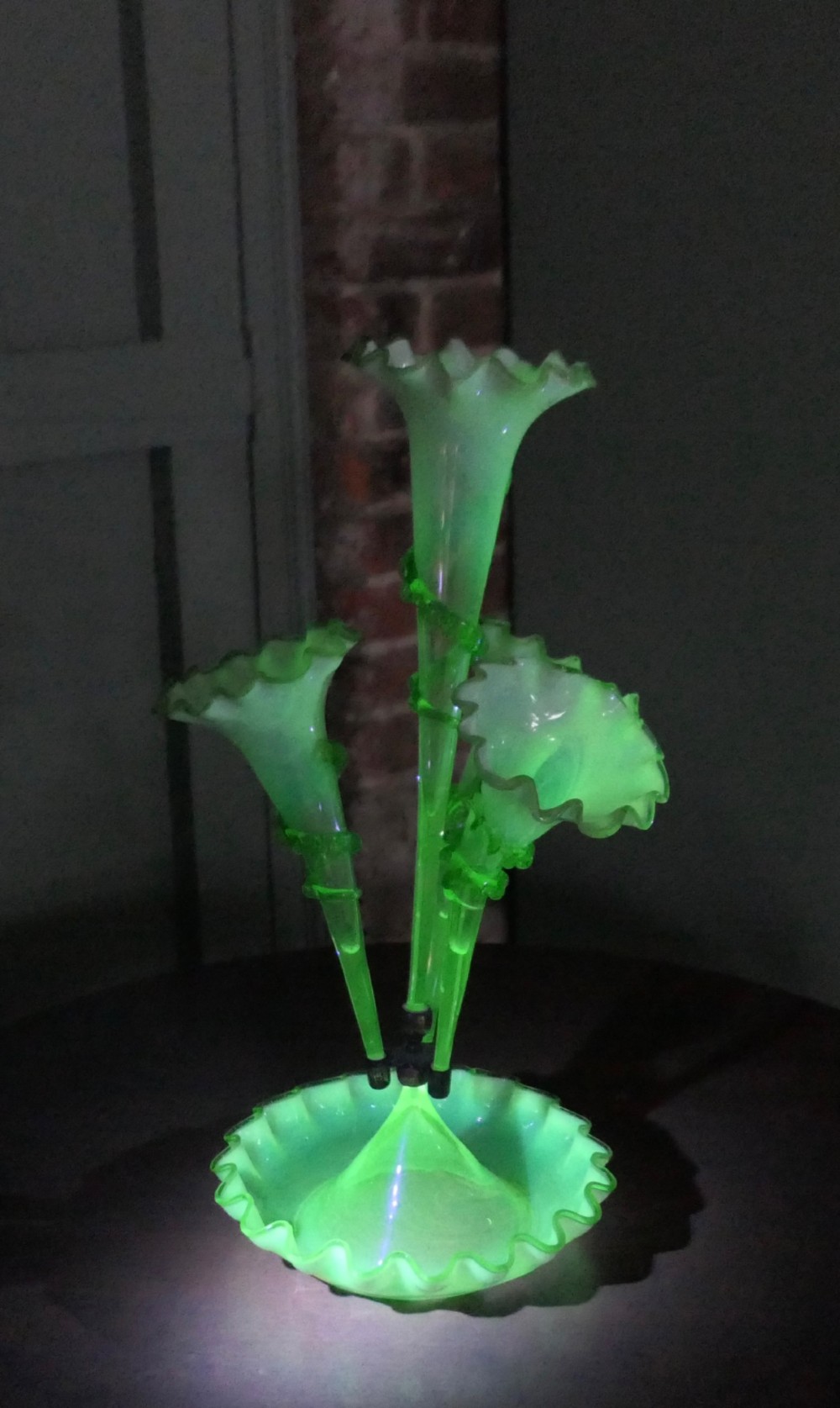 A nineteenth-century hand-blown uranium glass epergne featuring four crimped trumpet stems with applied green glass trailing mounted above an opalescent bowl base. View IV