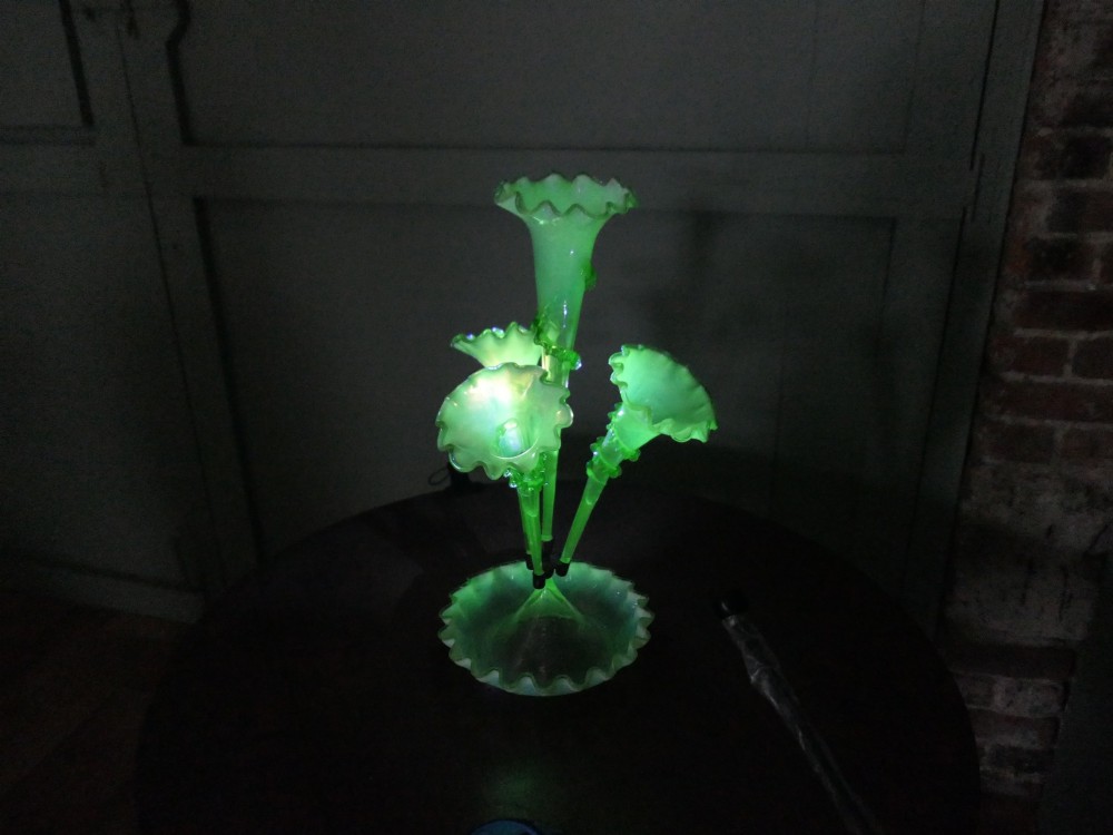 A nineteenth-century hand-blown uranium glass epergne featuring four crimped trumpet stems with applied green glass trailing mounted above an opalescent bowl base. View V
