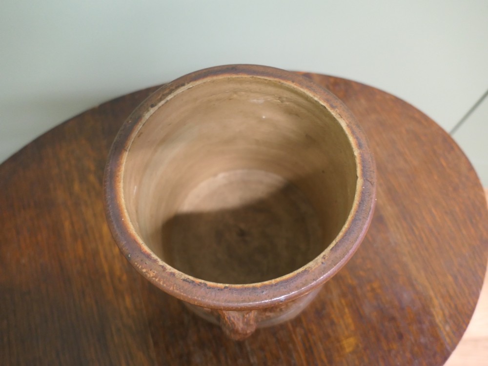 A cylindrical brown glazed stoneware tobacco pot featuring raised lettering that reads TABAC surrounded by oak leaf and acorn garlands. View V