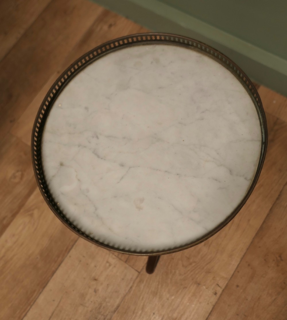 A French Napoleon III style circular wine table with a white marble top, pierced brass gallery, turned central wood column, and tripod legs. View IV