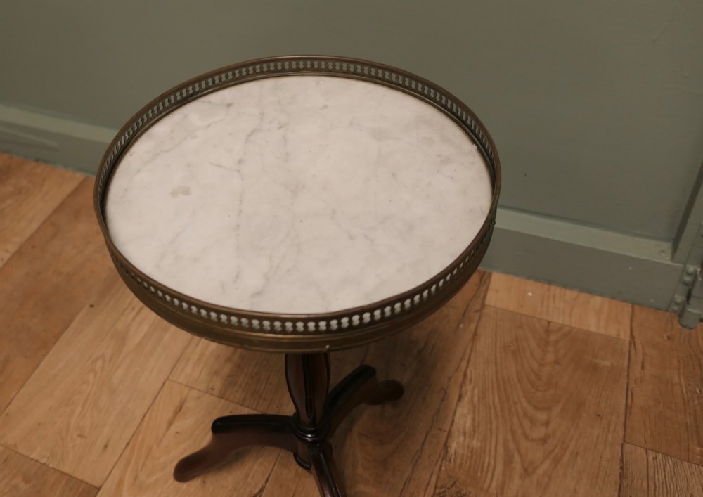 A French Napoleon III style circular wine table with a white marble top, pierced brass gallery, turned central wood column, and tripod legs. View VI