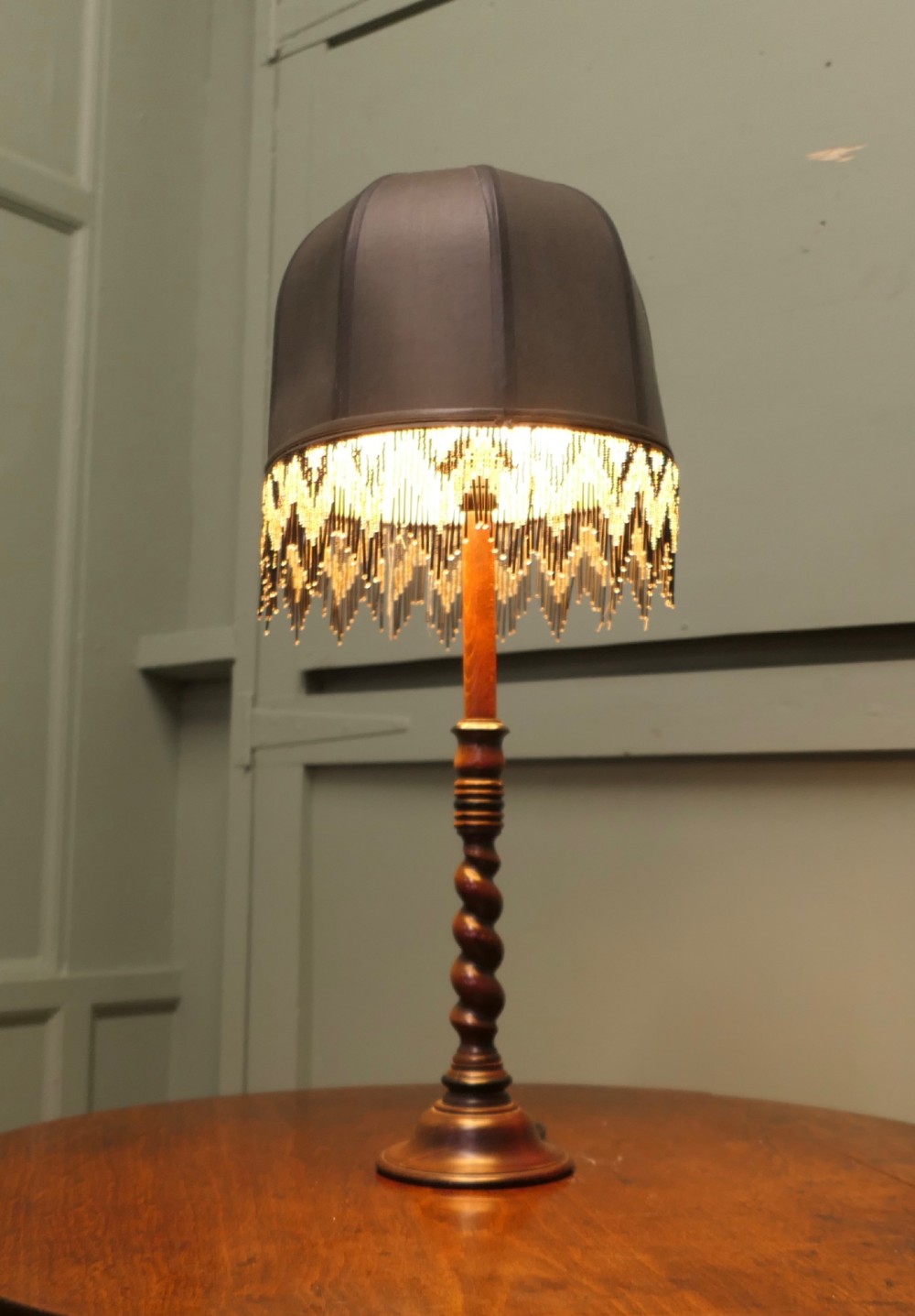 A wooden table lamp featuring a turned barley twist stem and a dark dome shade adorned with glass bead fringe. View III