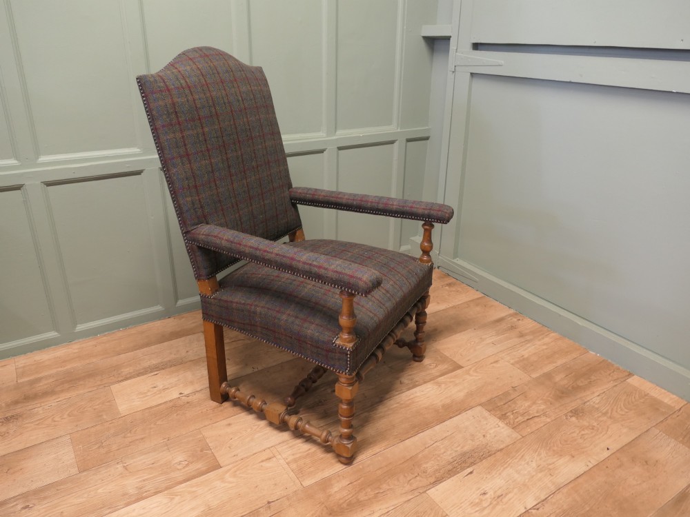 An upholstered high-back armchair with tweed plaid fabric, brass studding, and turned oak legs with stretchers. View V