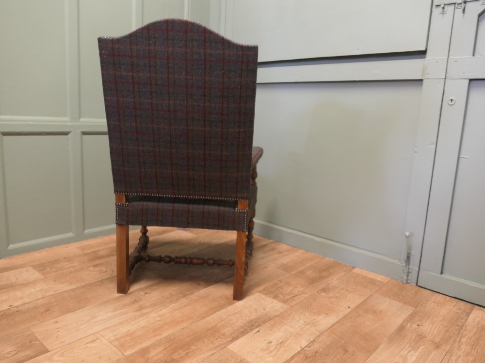 An upholstered high-back armchair with tweed plaid fabric, brass studding, and turned oak legs with stretchers. View VI