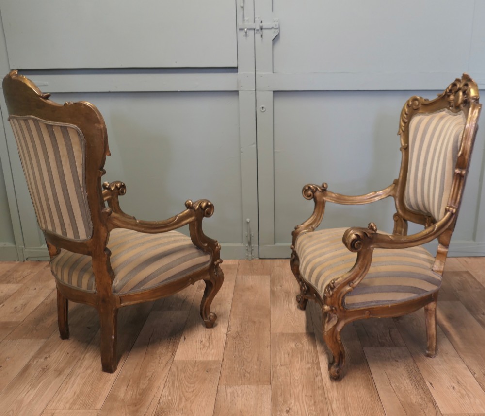 A pair of ornate Italian Rococo style armchairs with carved giltwood frames and grey and gold striped upholstery. View IV