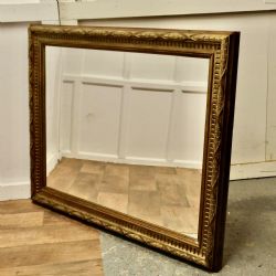 A LARGE CARVED OAK AND GILDED WALL MIRROR