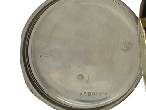 fig 4. An open-faced Longines pocket watch with a silver case, white enamel dial, black Arabic numerals, and a subsidiary seconds dial.