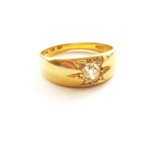 fig 1. A Victorian yellow gold band ring featuring a single cushion cut diamond flush set inside an engraved starburst motif.