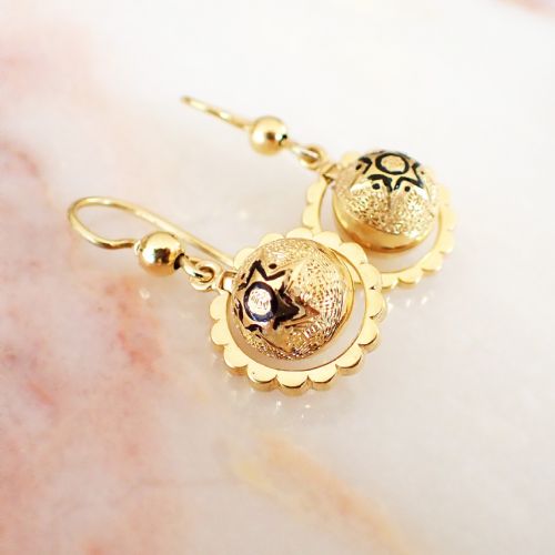 fig 1. A pair of Victorian 15ct yellow gold drop earrings featuring central textured domes decorated with black enamel star motifs inside scalloped circular borders.