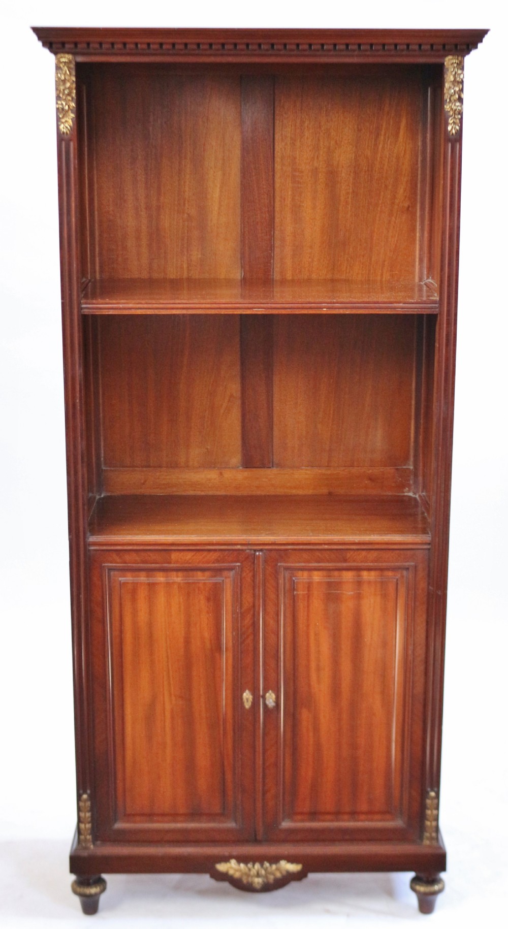 A tall Victorian mahogany open-top cabinet with two shelves over a two-door cupboard base fitted with gilt-metal mounts.