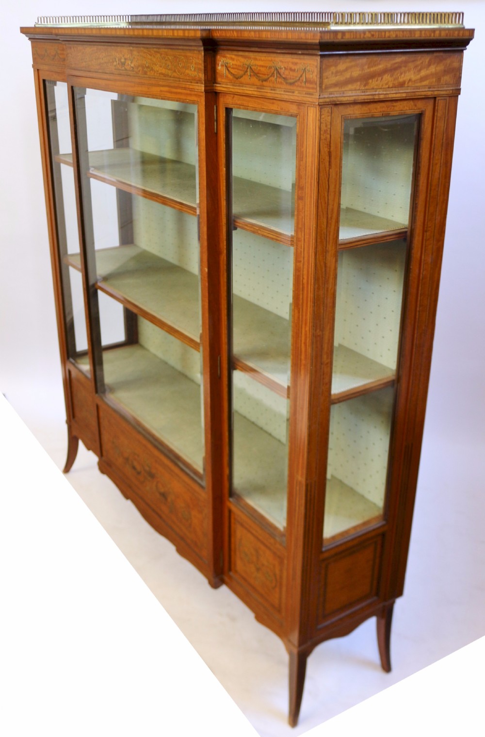 An Edwardian satinwood display cabinet featuring a breakfront design with glazed panels, floral marquetry inlay, and a brass top gallery. View III