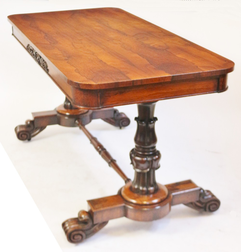 A William IV rosewood centre table featuring a rectangular top with rounded corners, a carved frieze, turned end supports, a low stretcher, and scroll feet. View V