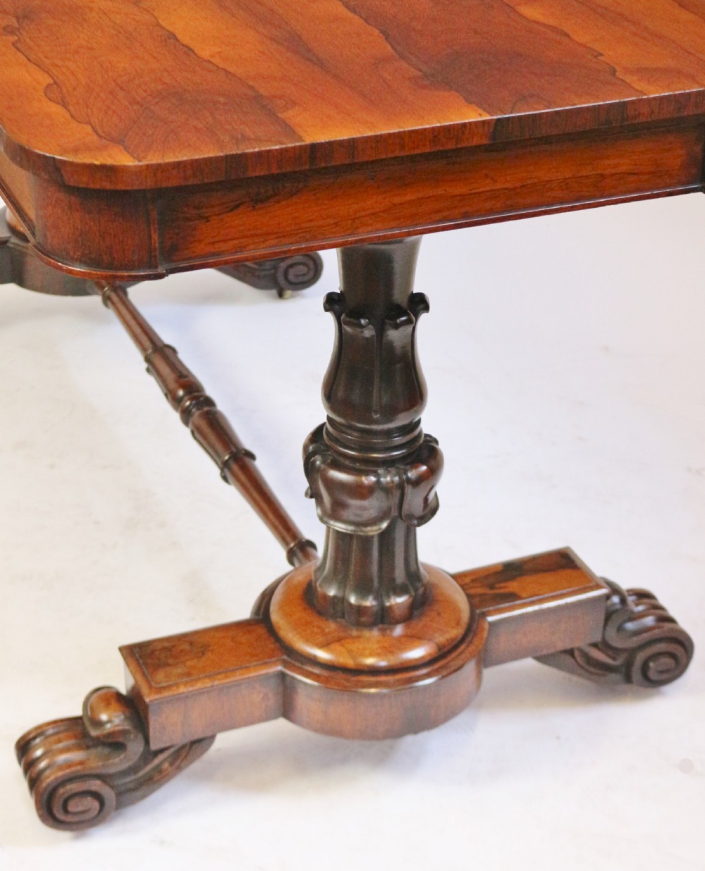 A William IV rosewood centre table featuring a rectangular top with rounded corners, a carved frieze, turned end supports, a low stretcher, and scroll feet. View VIII