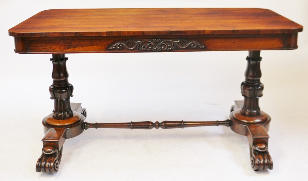 A William IV rosewood centre table featuring a rectangular top with rounded corners, a carved frieze, turned end supports, a low stretcher, and scroll feet. View IX