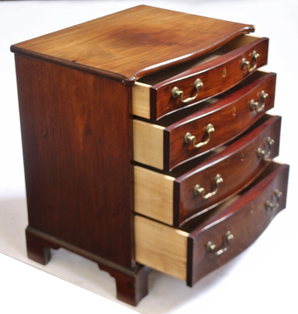 A George III mahogany serpentine chest of drawers featuring four drawers with brass swan-neck handles and bracket feet. View II