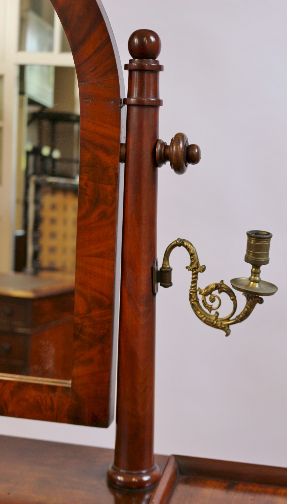 A William IV mahogany dressing table featuring an arched swivel mirror, brass sconces, upper drawers, and carved front columns on a plinth base. View VII