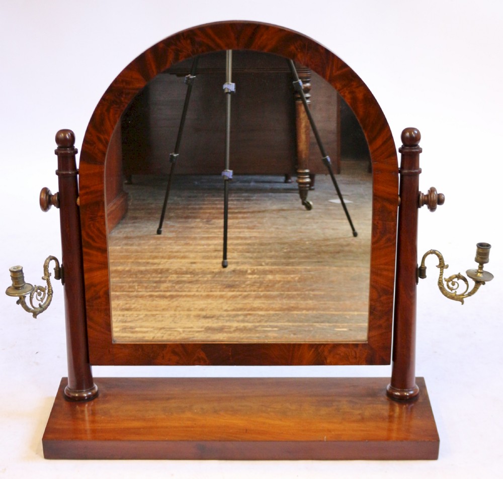 A William IV mahogany dressing table featuring an arched swivel mirror, brass sconces, upper drawers, and carved front columns on a plinth base. View XV