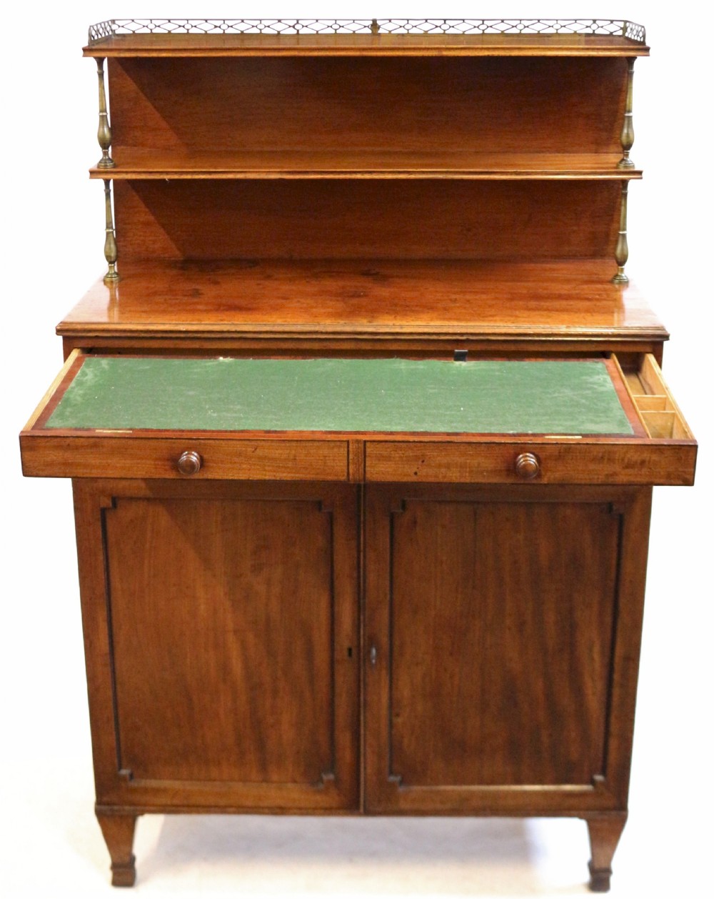 A Regency mahogany chiffonier with a two-tier brass-galleried shelf unit above a fitted writing drawer and two-door cabinet base. View II