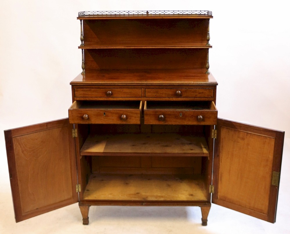 A Regency mahogany chiffonier with a two-tier brass-galleried shelf unit above a fitted writing drawer and two-door cabinet base. View V