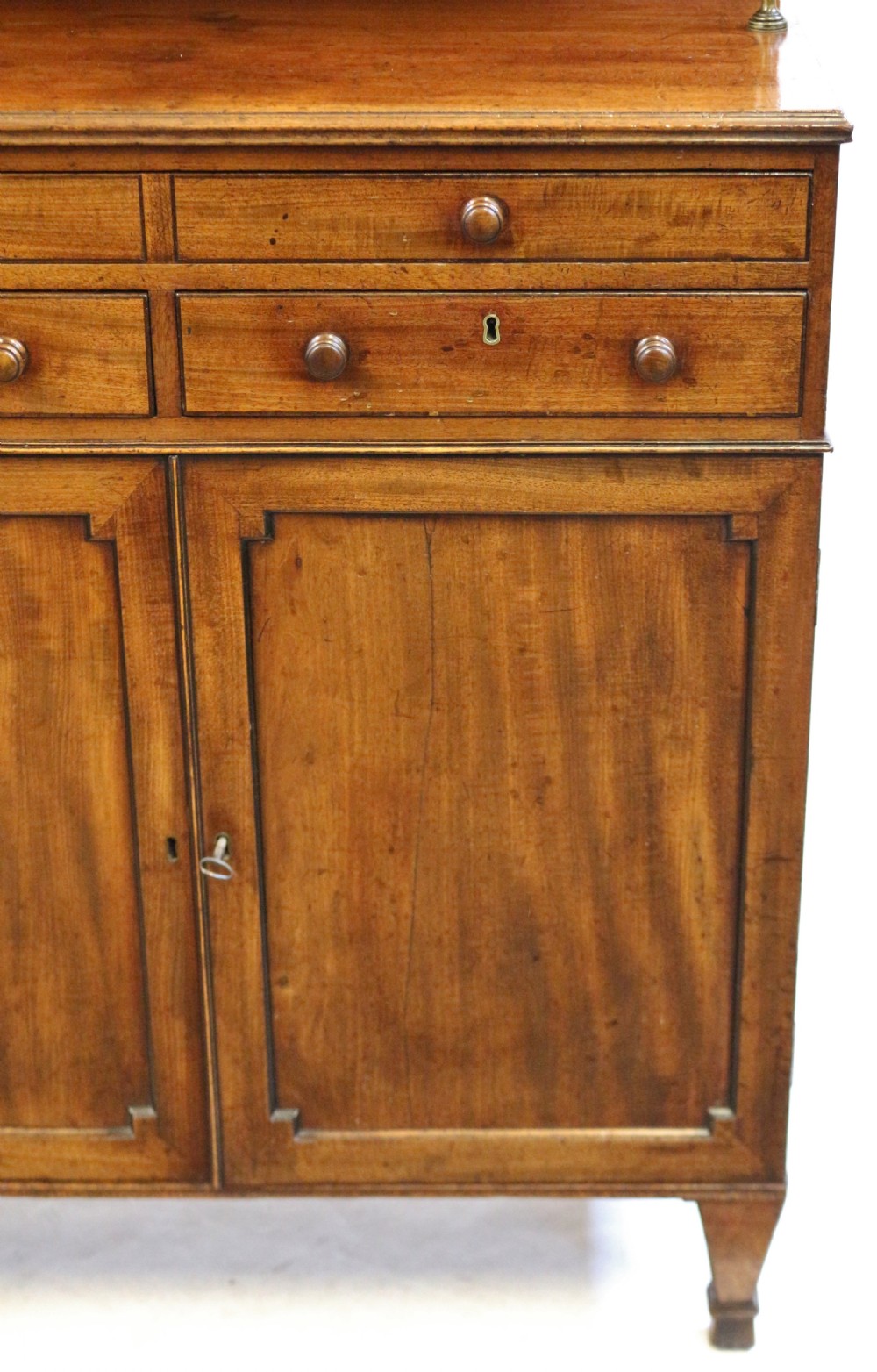 A Regency mahogany chiffonier with a two-tier brass-galleried shelf unit above a fitted writing drawer and two-door cabinet base. View XI