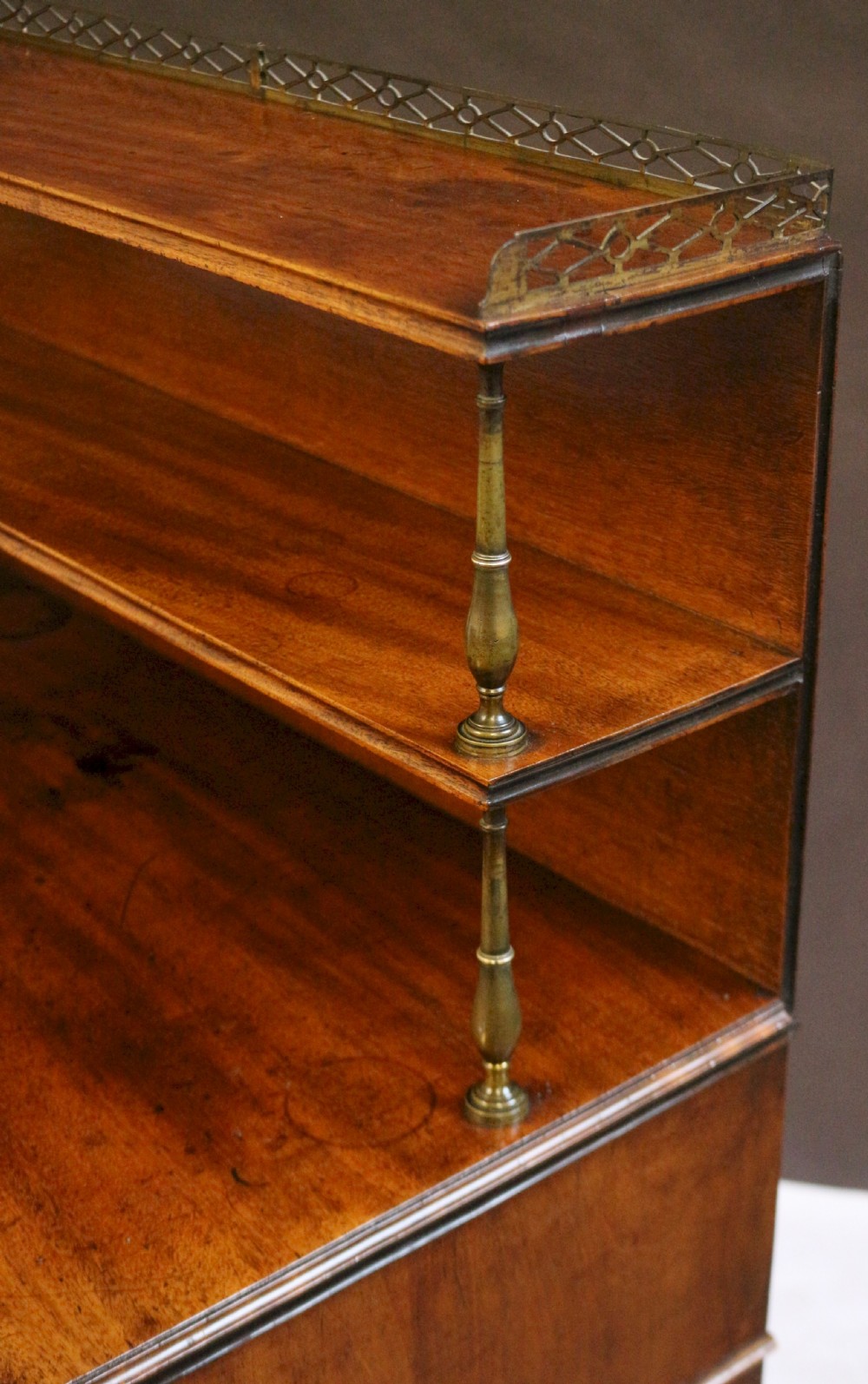 A Regency mahogany chiffonier with a two-tier brass-galleried shelf unit above a fitted writing drawer and two-door cabinet base. View XIII