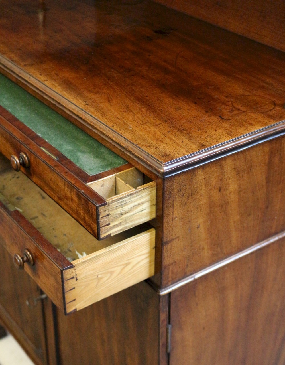 A Regency mahogany chiffonier with a two-tier brass-galleried shelf unit above a fitted writing drawer and two-door cabinet base. View XIV