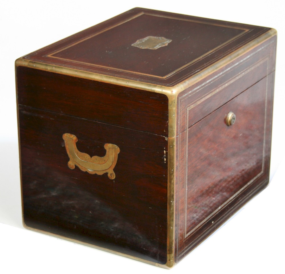 An opened 19th-century rosewood box with brass inlay featuring a green velvet fitted interior containing silver-capped jars and grooming implements. View XV
