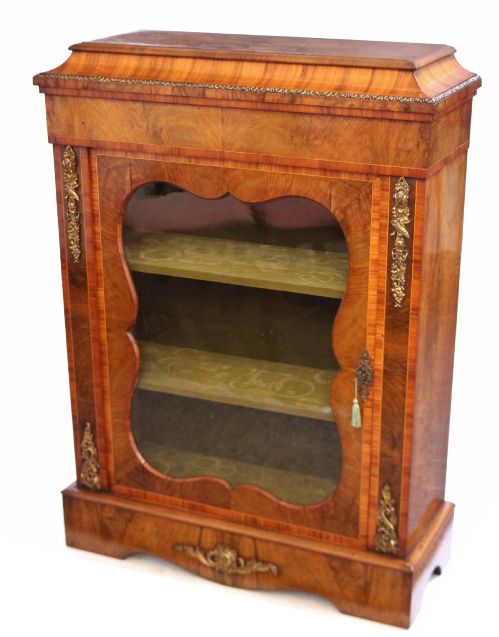 A Victorian walnut and kingwood pier cabinet with a single glazed door, brass mounts, and internal display shelves. View II