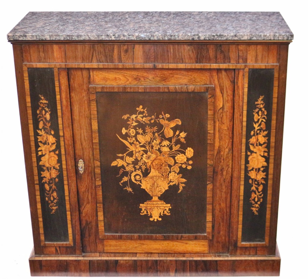 A Victorian rosewood side cupboard featuring an inlaid floral marquetry central door, flanking inlaid side panels, and a grey marble top.