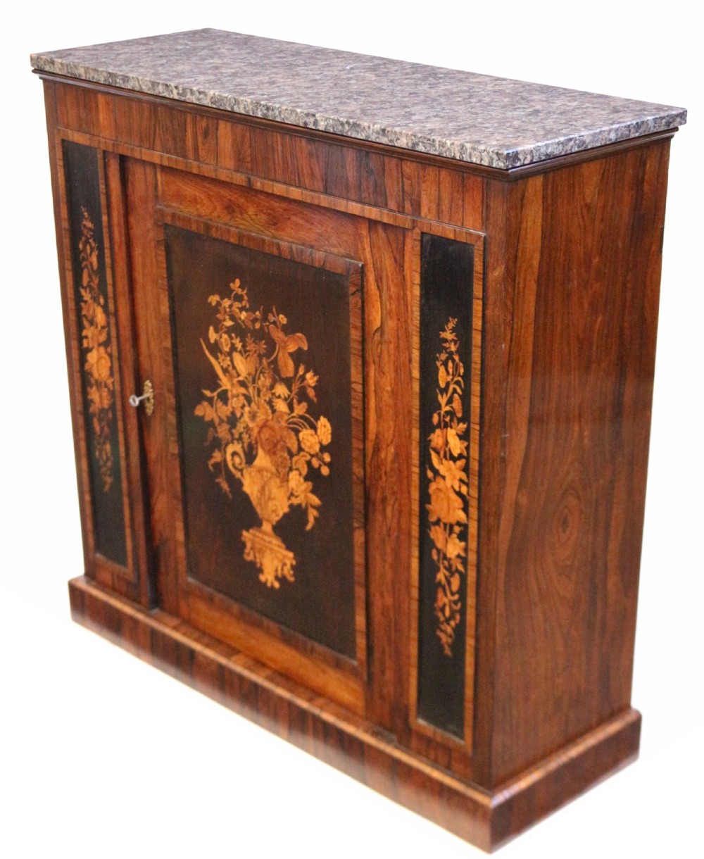 A Victorian rosewood side cupboard featuring an inlaid floral marquetry central door, flanking inlaid side panels, and a grey marble top. View V