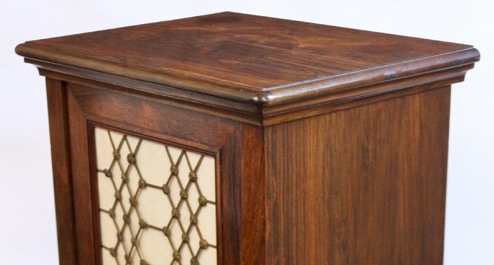 An antique William IV rosewood cupboard featuring a single door inset with a decorative brass lattice grille over a cream fabric backing. View IV