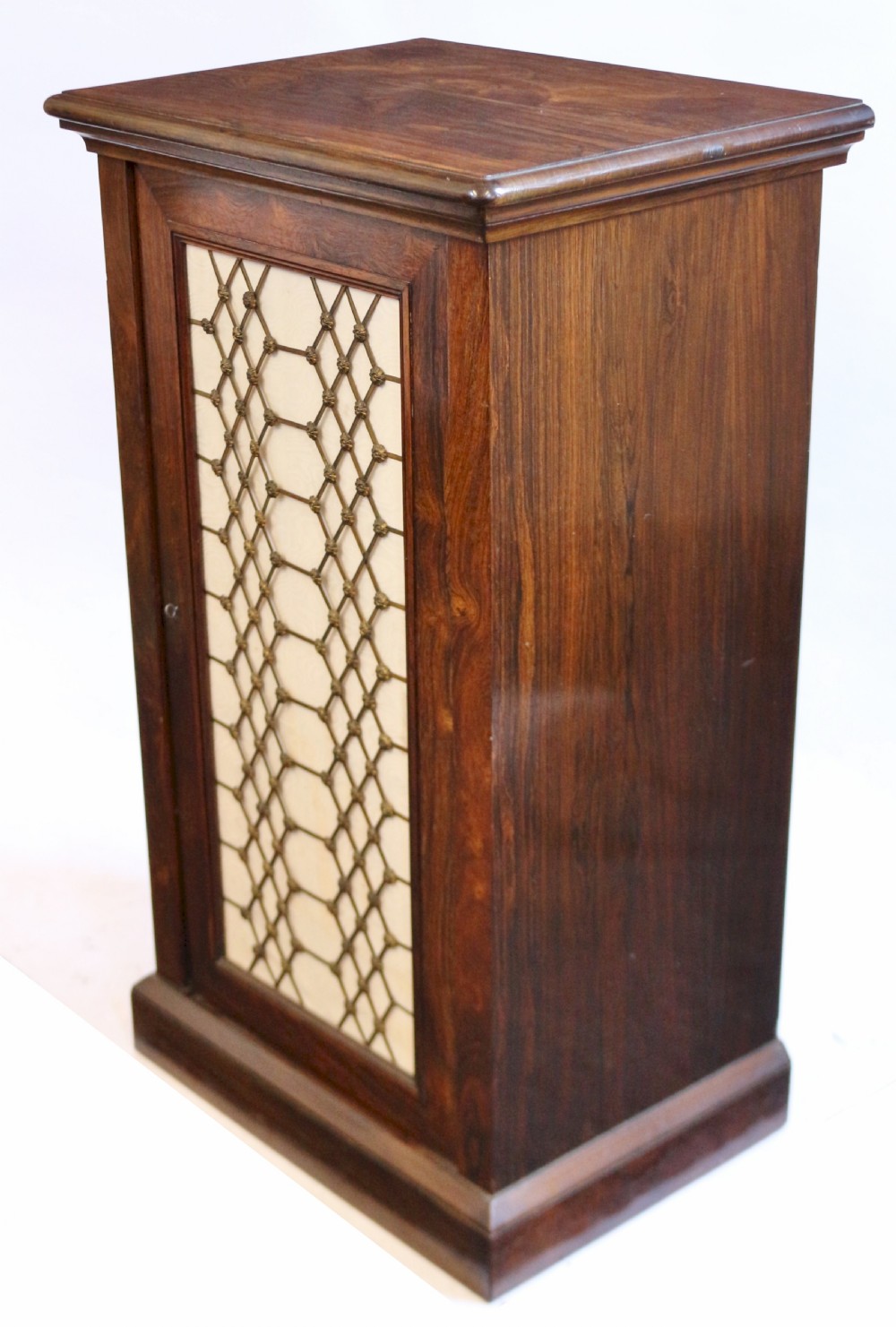 An antique William IV rosewood cupboard featuring a single door inset with a decorative brass lattice grille over a cream fabric backing. View V