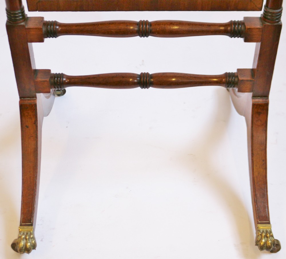 A Regency mahogany cheval mirror featuring a rectangular swivelling frame set between turned upright posts with brass castors. View V